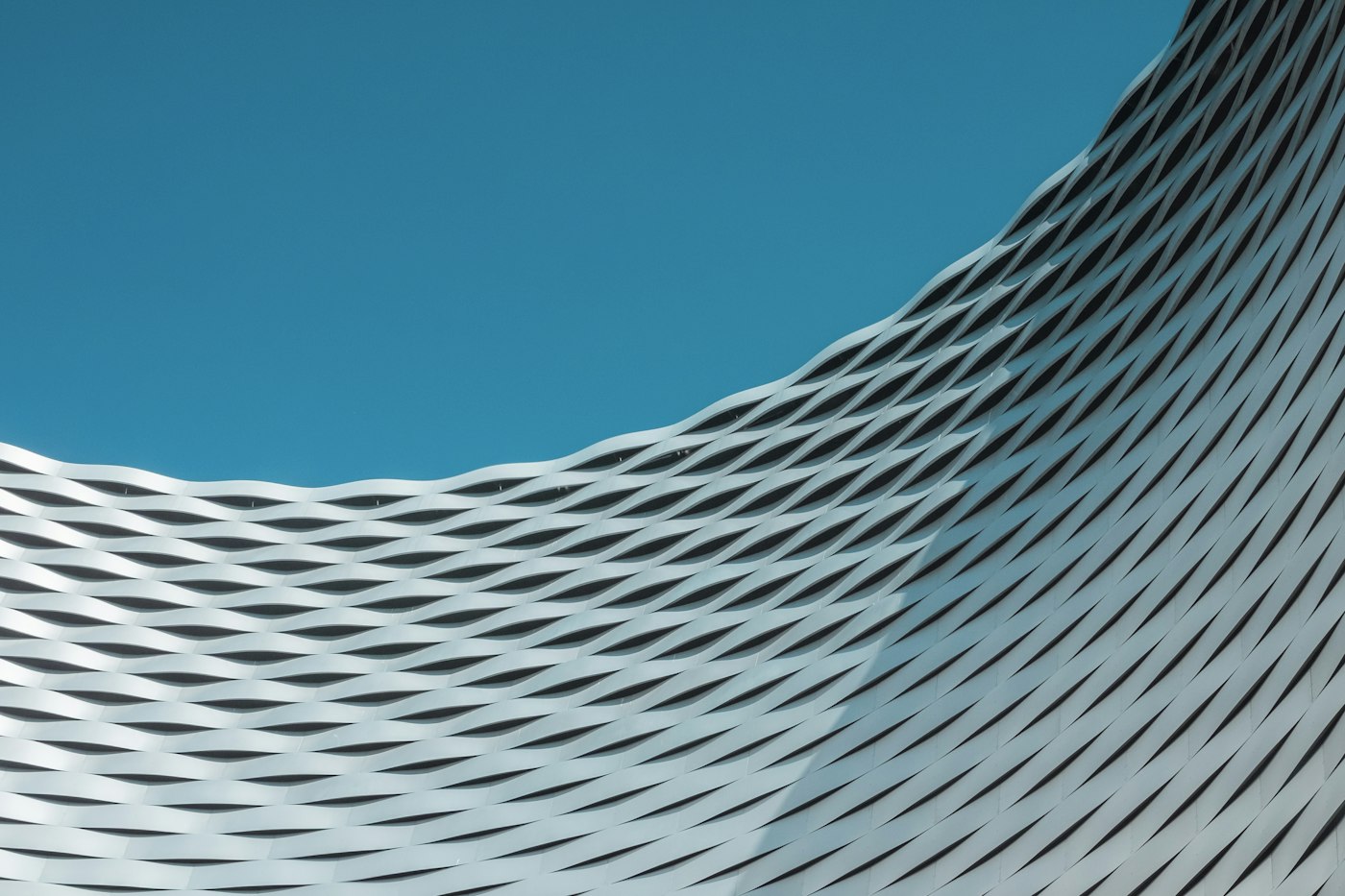 Curved white building against blue sky